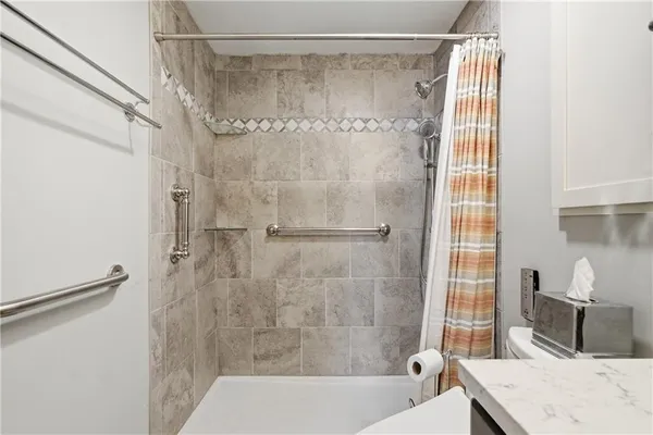 a bathroom with a granite countertop shower a sink and a mirror