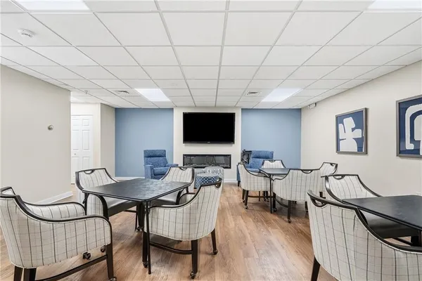 a living room with furniture a flat screen tv and a table
