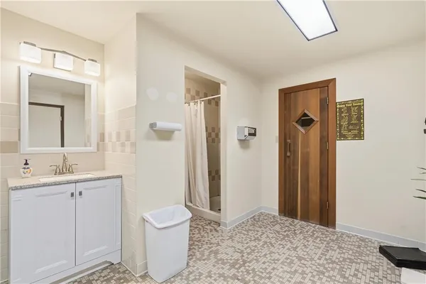 a bathroom with a sink a toilet and shower