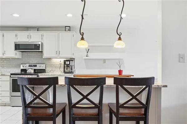 a kitchen with a table chairs refrigerator and microwave