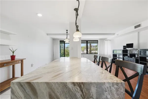 a large kitchen with sink a refrigerator and chairs