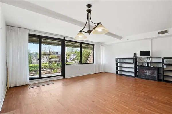 a view of empty room with wooden floor and windows