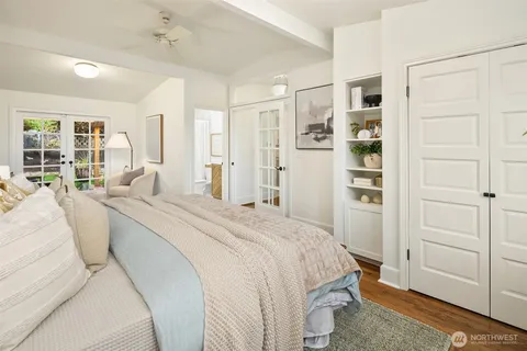 a spacious bedroom with a bed a couch and large window