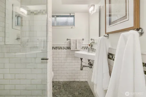 a bathroom with a sink a shower and a mirror
