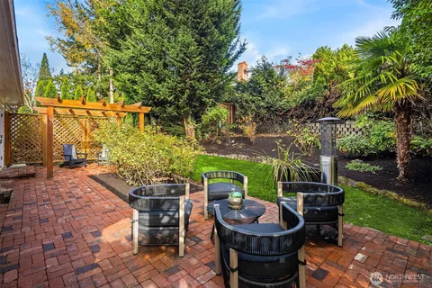 a view of a patio with table and chairs potted plants and a large tree