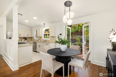 a kitchen with a dining table chairs and white cabinets