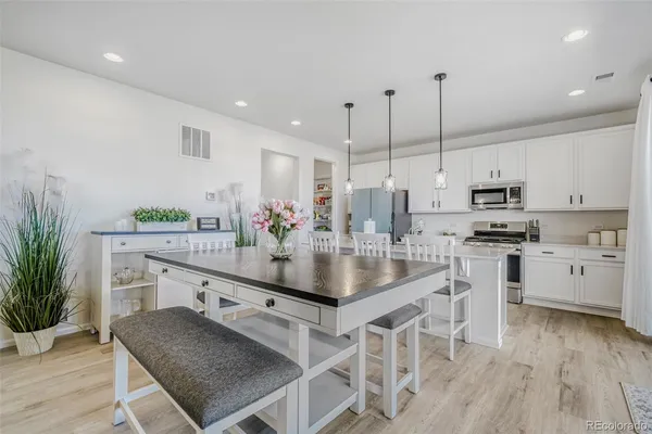 a kitchen with stainless steel appliances kitchen island granite countertop a stove a sink and a refrigerator
