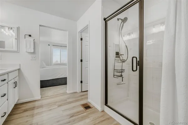 a bathroom with a glass shower door and a mirror
