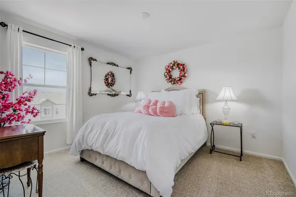 a bedroom with a bed and a potted plant on dresser