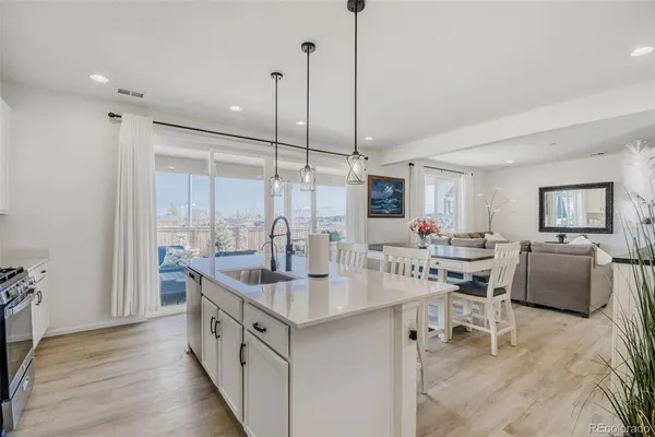 a kitchen with stainless steel appliances granite countertop a sink a counter and chairs