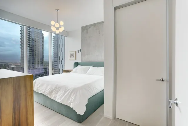 a bedroom with a bed table and a chandelier