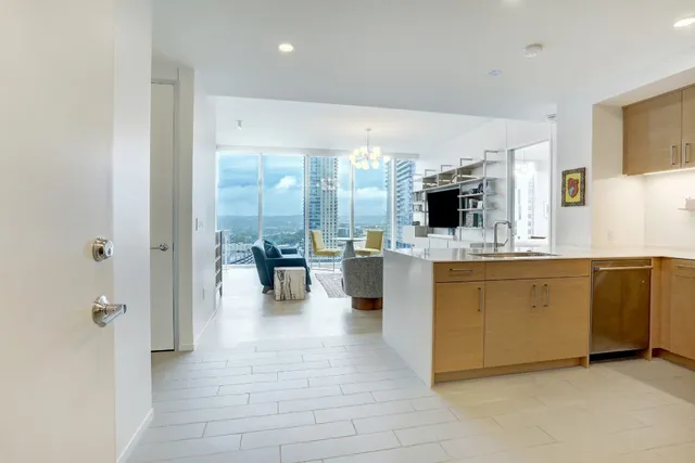 a large white kitchen with a large window and stainless steel appliances