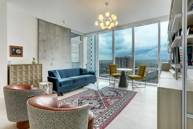 a living room with furniture large window and a table