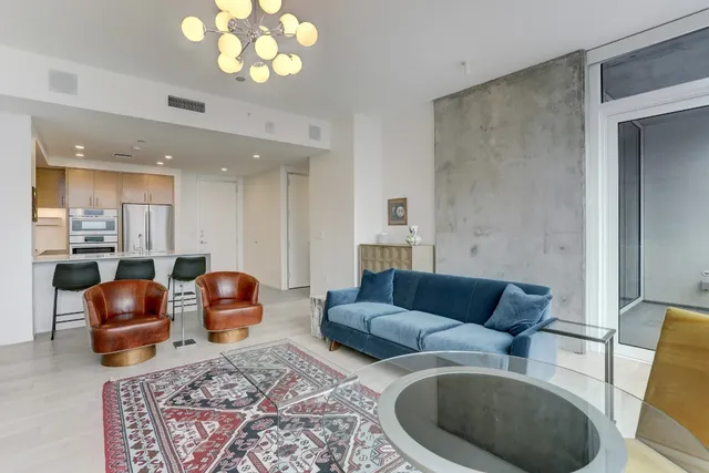 a living room with furniture a couch and kitchen view