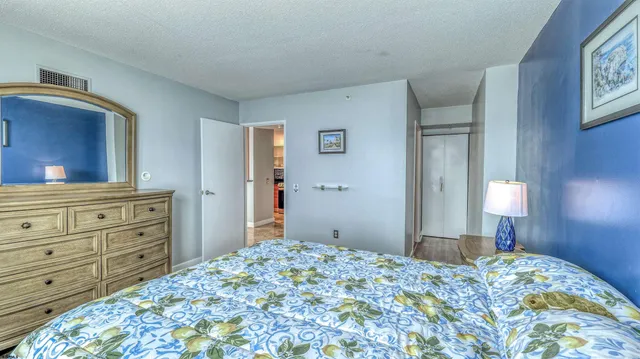 a bedroom with a bed and a dresser with wooden floor