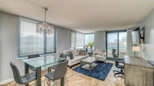 a living room with couch a table and a chandelier