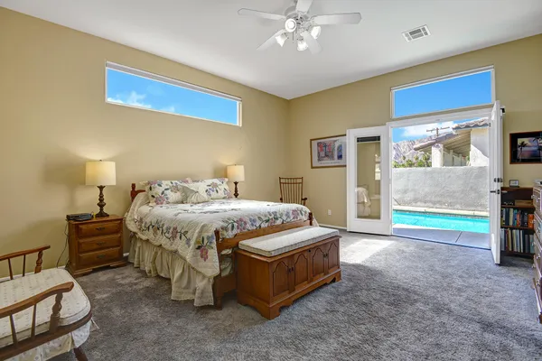 a spacious bedroom with a bed and a chandelier