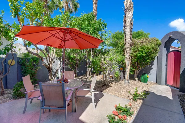 a view of a patio with table and chairs under an umbrella