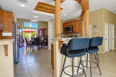 a dining hall with stainless steel appliances granite countertop a table and chairs with wooden floor