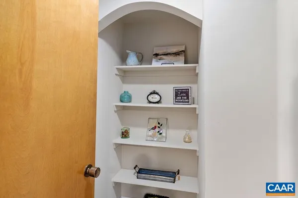 a bedroom with a bed and a lamp on dresser