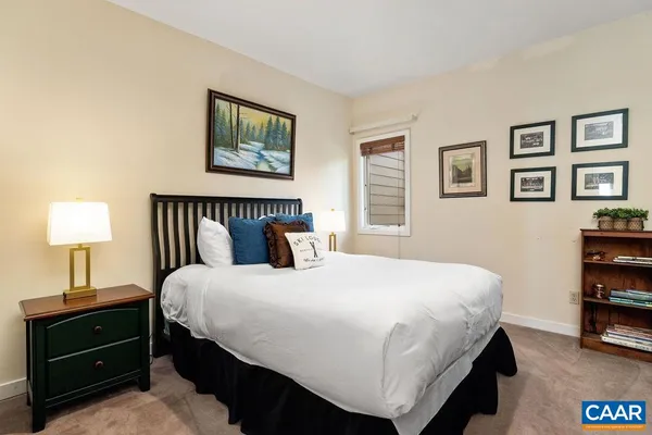 a bedroom with a bed and a painting on the wall