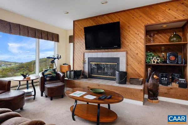 a living room with furniture a flat screen tv and a fireplace