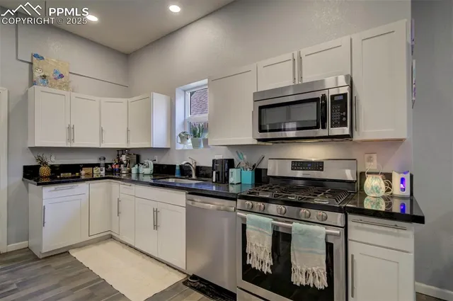 a kitchen with stainless steel appliances granite countertop a sink and stove top oven