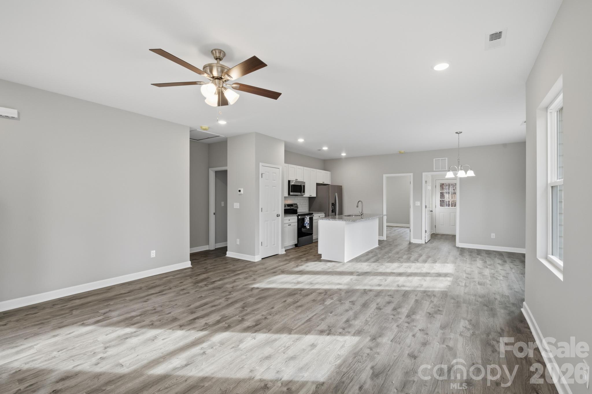 368 Lippard Farm Road Statesville, NC 28625 - Photo 15 of 29 a view of a livingroom with a ceiling fan and kitchen view