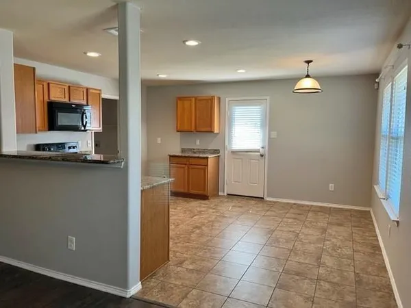 a large kitchen with stainless steel appliances granite countertop a stove a sink and a microwave