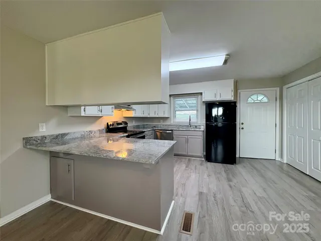 a kitchen with granite countertop a sink and a stove top oven