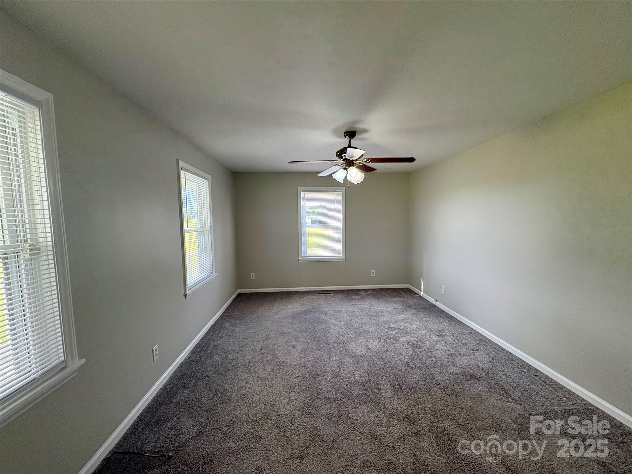 3123 Stack Road Monroe, NC 28112 - Photo 20 of 28 an empty room with windows and chandelier fan