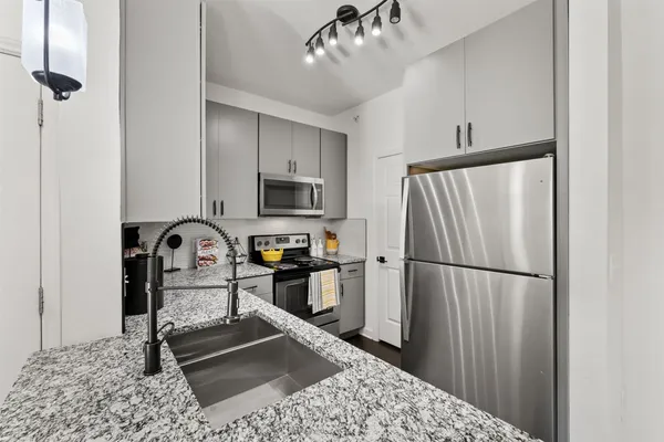a kitchen with stainless steel appliances granite countertop a refrigerator sink and stove