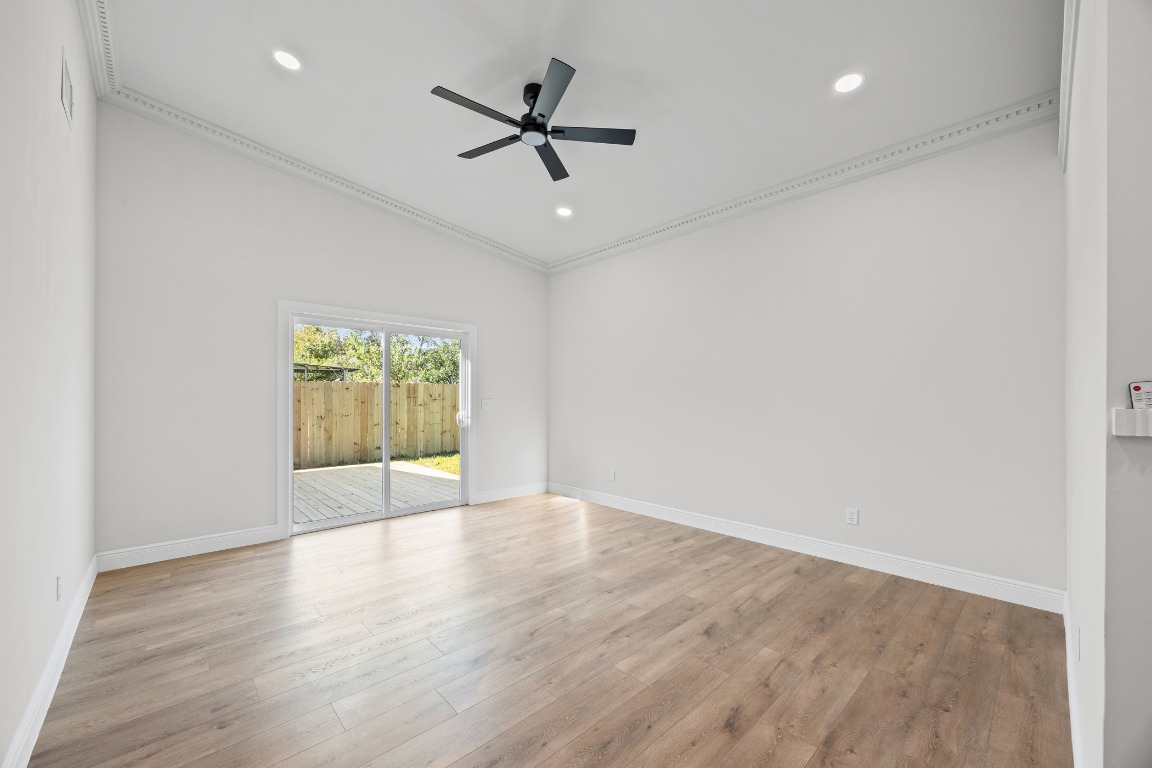 1712 Hillcrest Lane Austin, TX 78721 - Photo 9 of 25 an empty room with a window and a ceiling fan