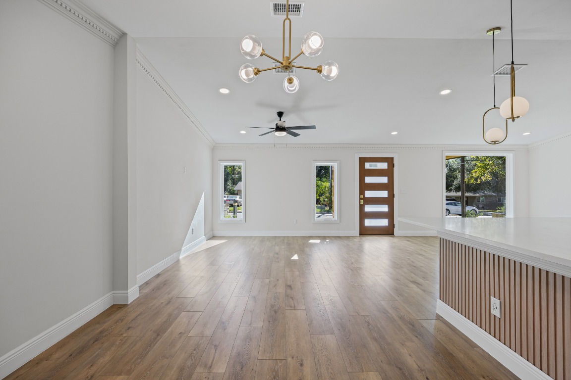 1712 Hillcrest Lane Austin, TX 78721 - Photo 4 of 25 a view of an empty room with a window and wooden floor