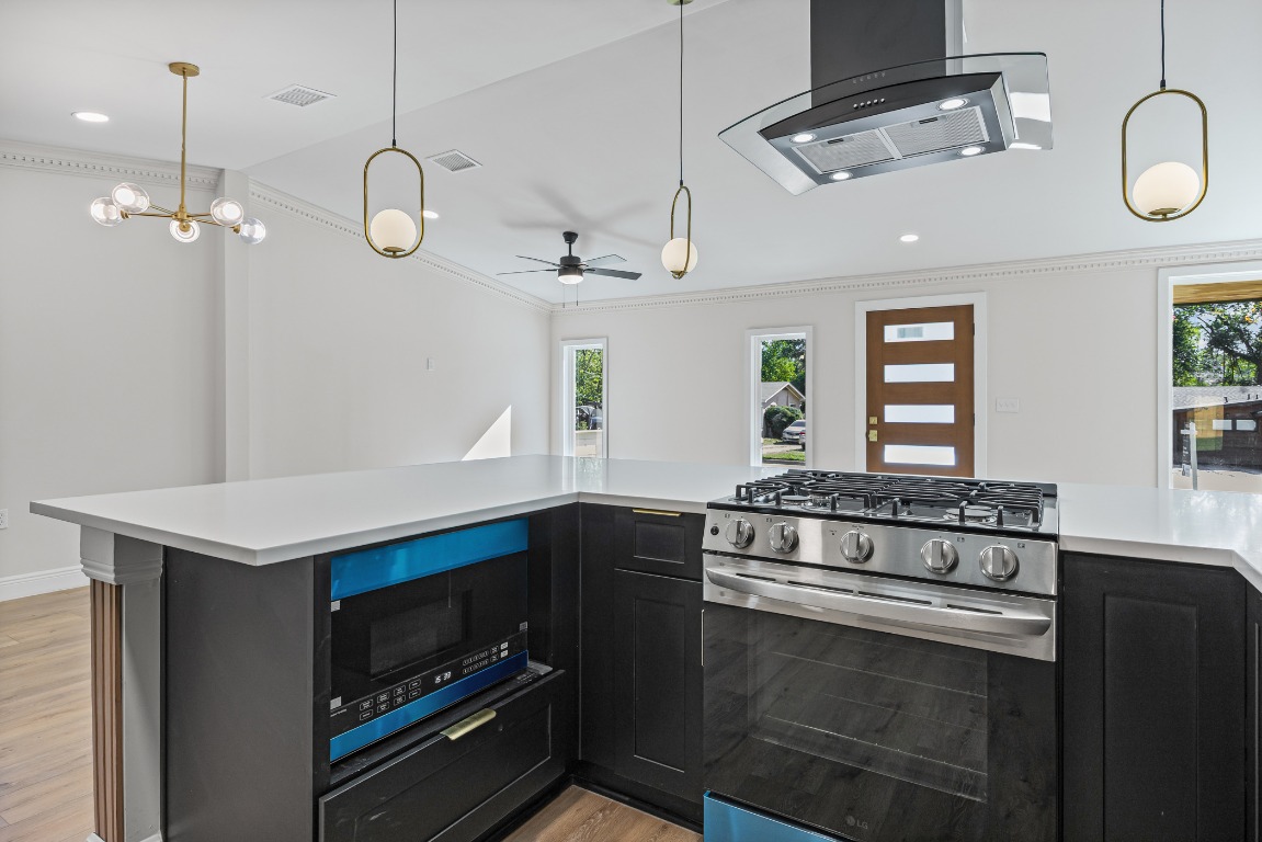 1712 Hillcrest Lane Austin, TX 78721 - Photo 7 of 25 a kitchen with a stove and a sink chandelier