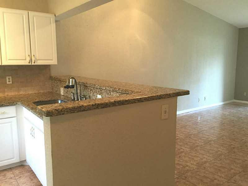21955 Tidewater Terrace, Unit 208 Boca Raton, FL 33433 - Photo 7 of 26 a kitchen with granite countertop a sink and a stove