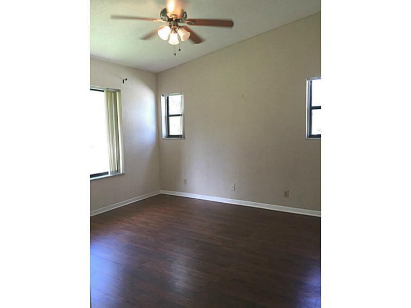 21955 Tidewater Terrace, Unit 208 Boca Raton, FL 33433 - Photo 10 of 26 a view of an empty room with wooden floor and a window