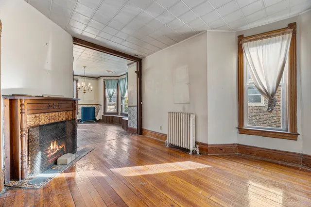 a view of an empty room with window and fire place