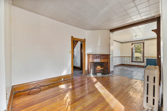 a view of a livingroom with wooden floor and a fireplace