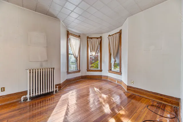 a view of a room with wooden floor and windows