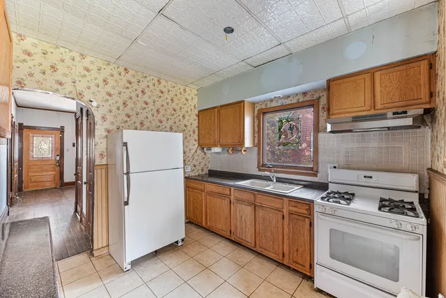 a kitchen with a stove top oven sink and refrigerator