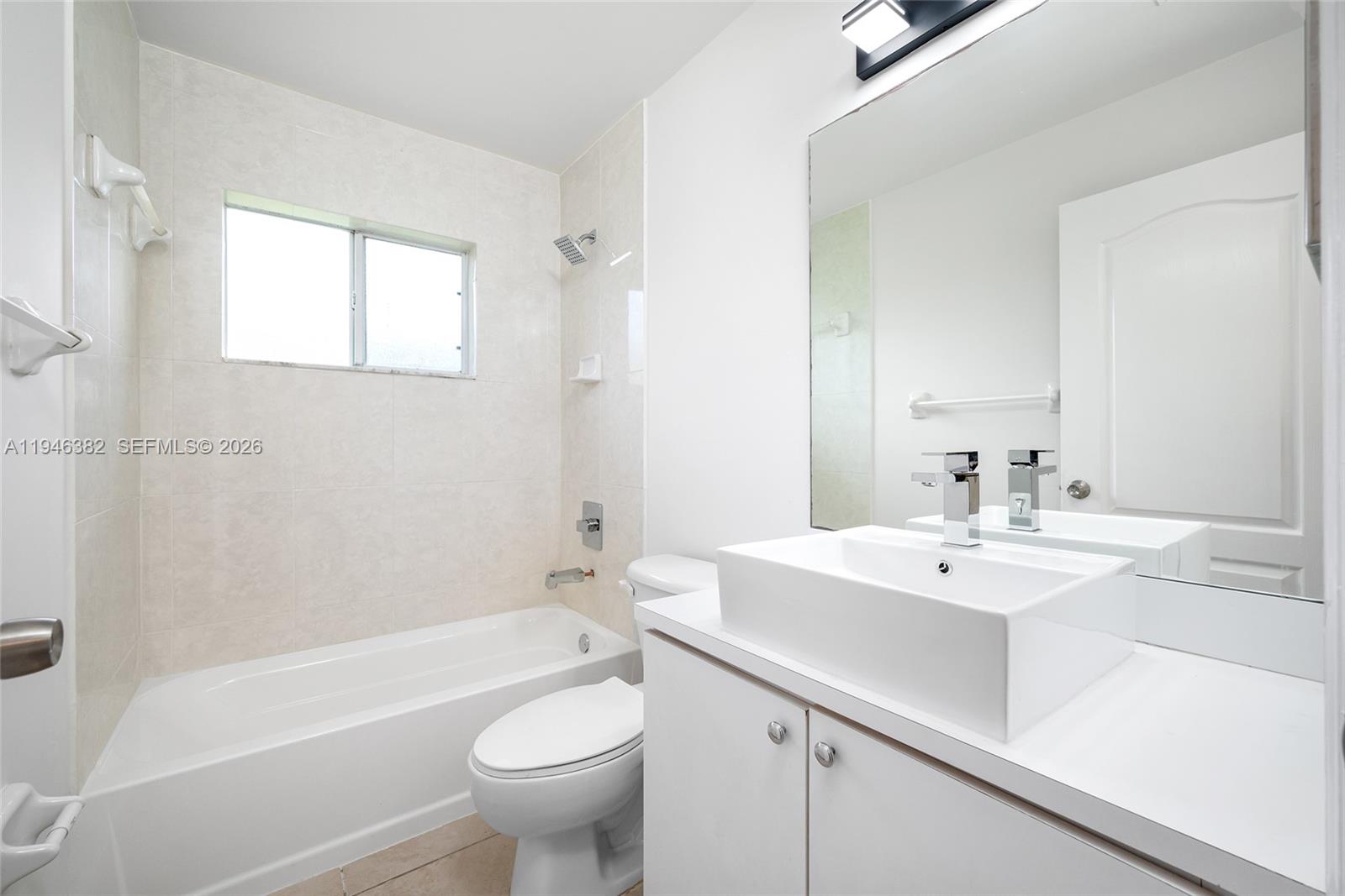 2275 Southwest 61st Avenue Miami, FL 33155 - Photo 20 of 53 a bathroom with a sink a toilet a mirror a bathtub and shower