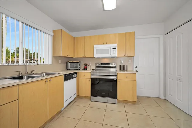 a kitchen with a refrigerator a stove a dining table and chairs