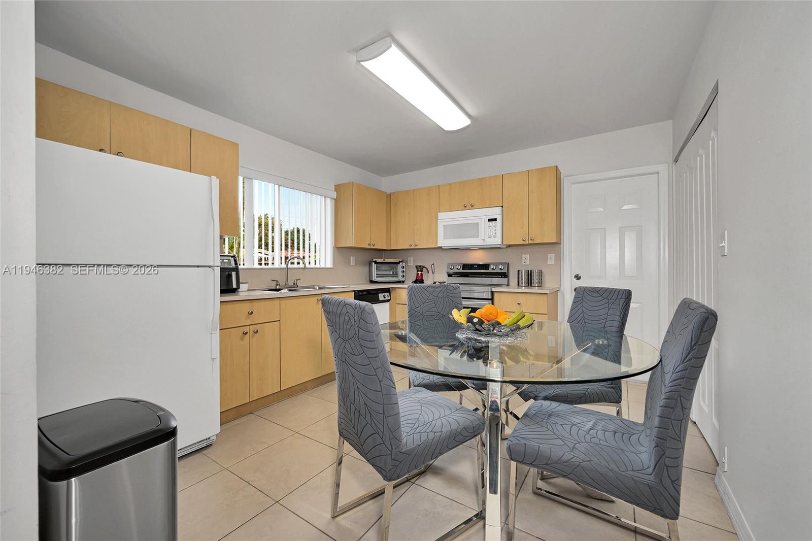 2275 Southwest 61st Avenue Miami, FL 33155 - Photo 33 of 53 a kitchen with a refrigerator a stove a dining table and chairs