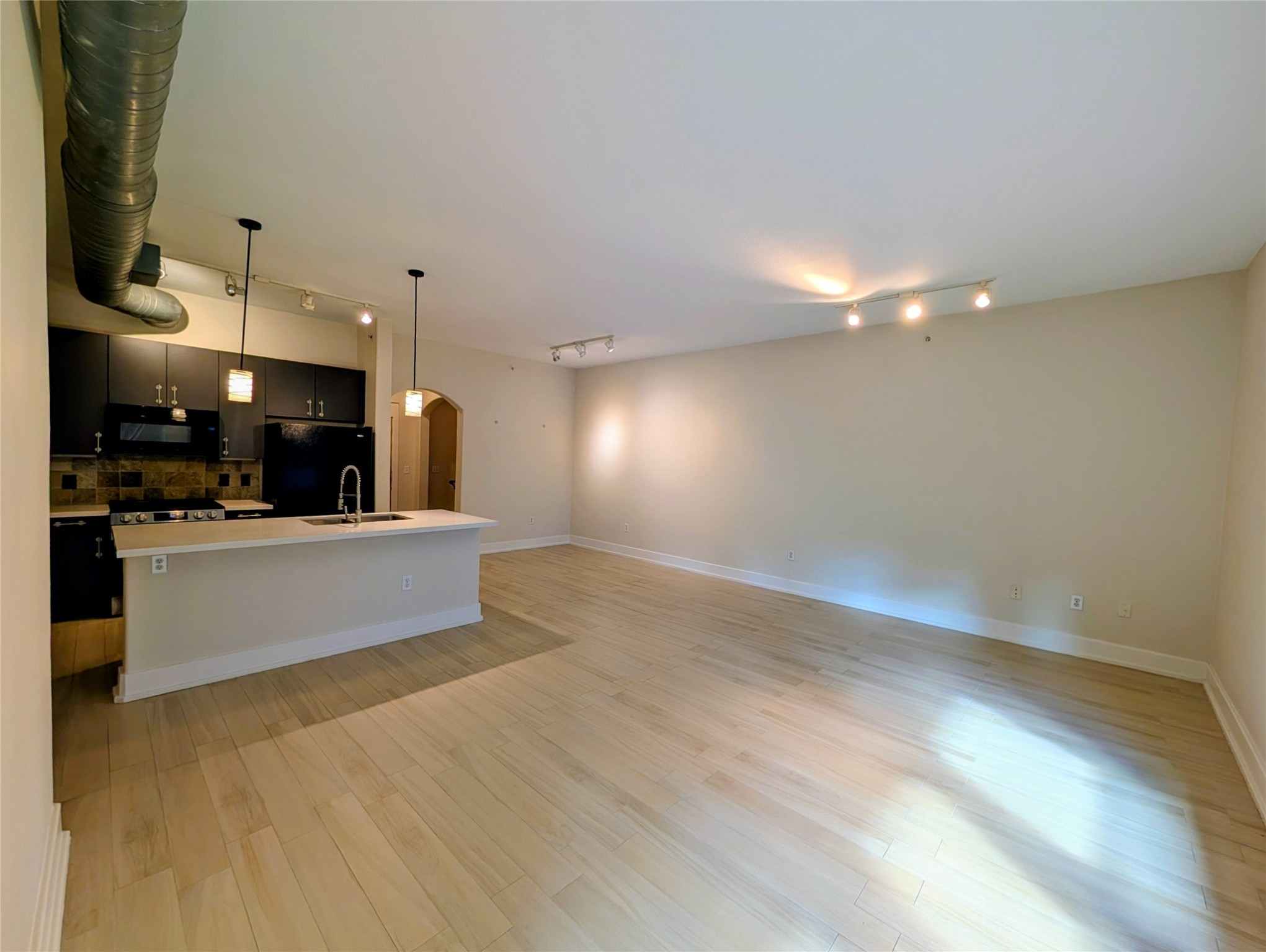 1901 Post Oak Boulevard, Unit 3101 Houston, TX 77056 - Photo 7 of 22 a large kitchen with stainless steel appliances a large counter top a stove and a wooden floors