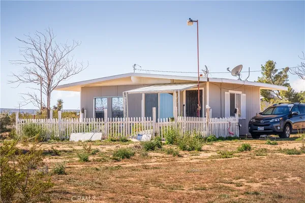 a front view of a house with a yard and outdoor seating