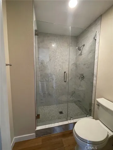 a white toilet next to a bathroom