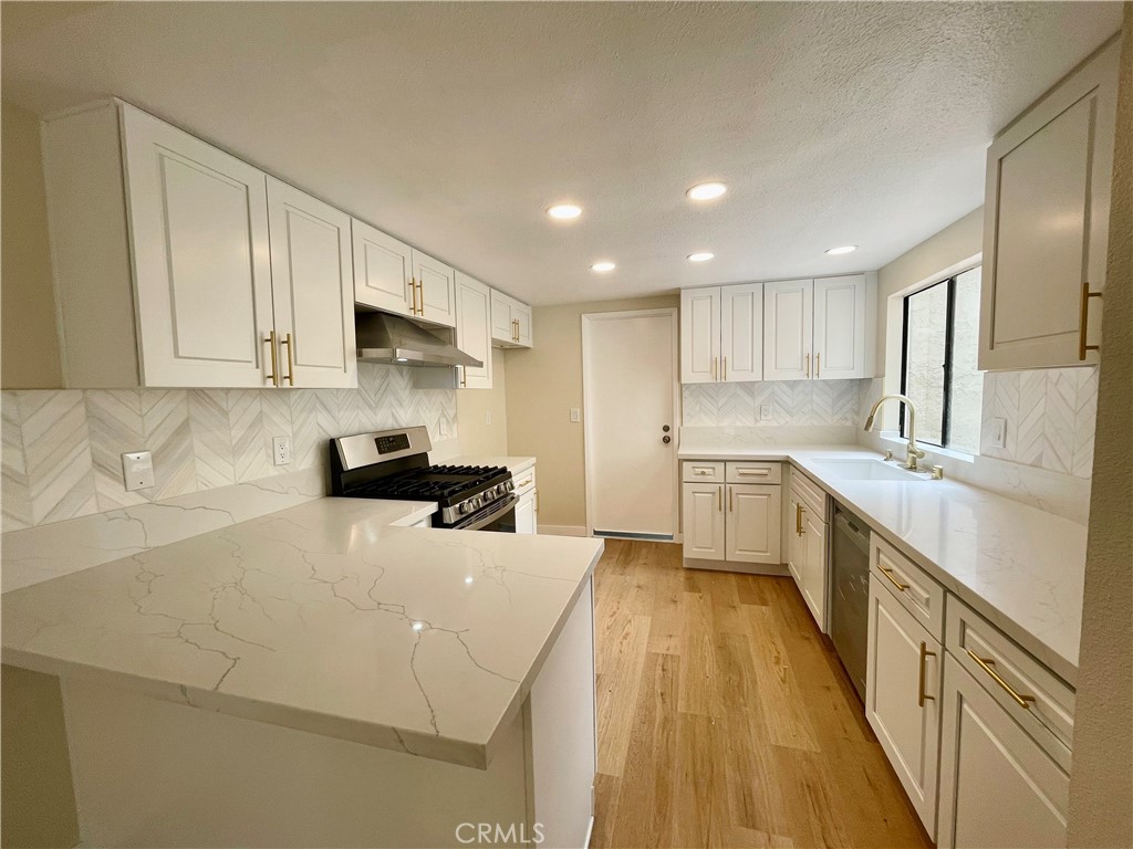 23 Sunfish, Unit 33 Irvine, CA 92604 - Photo 4 of 32 a kitchen with sink a counter top space stainless steel appliances and cabinets