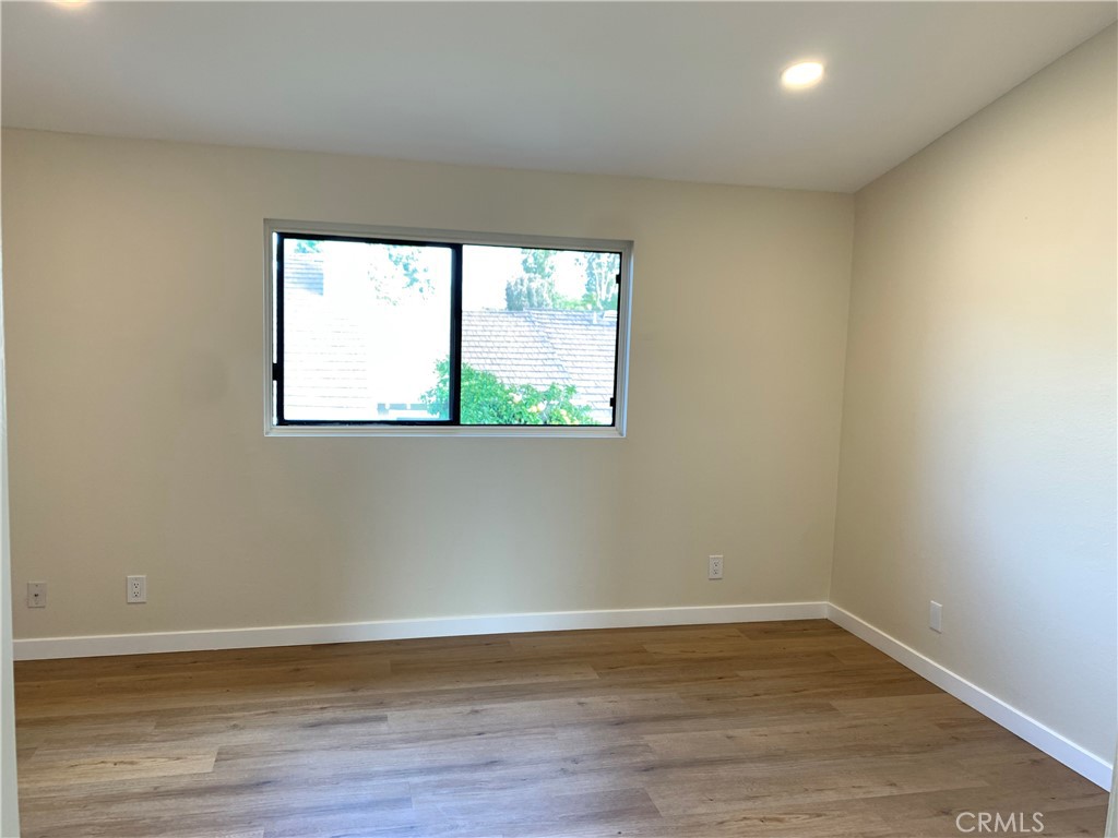23 Sunfish, Unit 33 Irvine, CA 92604 - Photo 9 of 32 a view of an empty room with wooden floor and a window