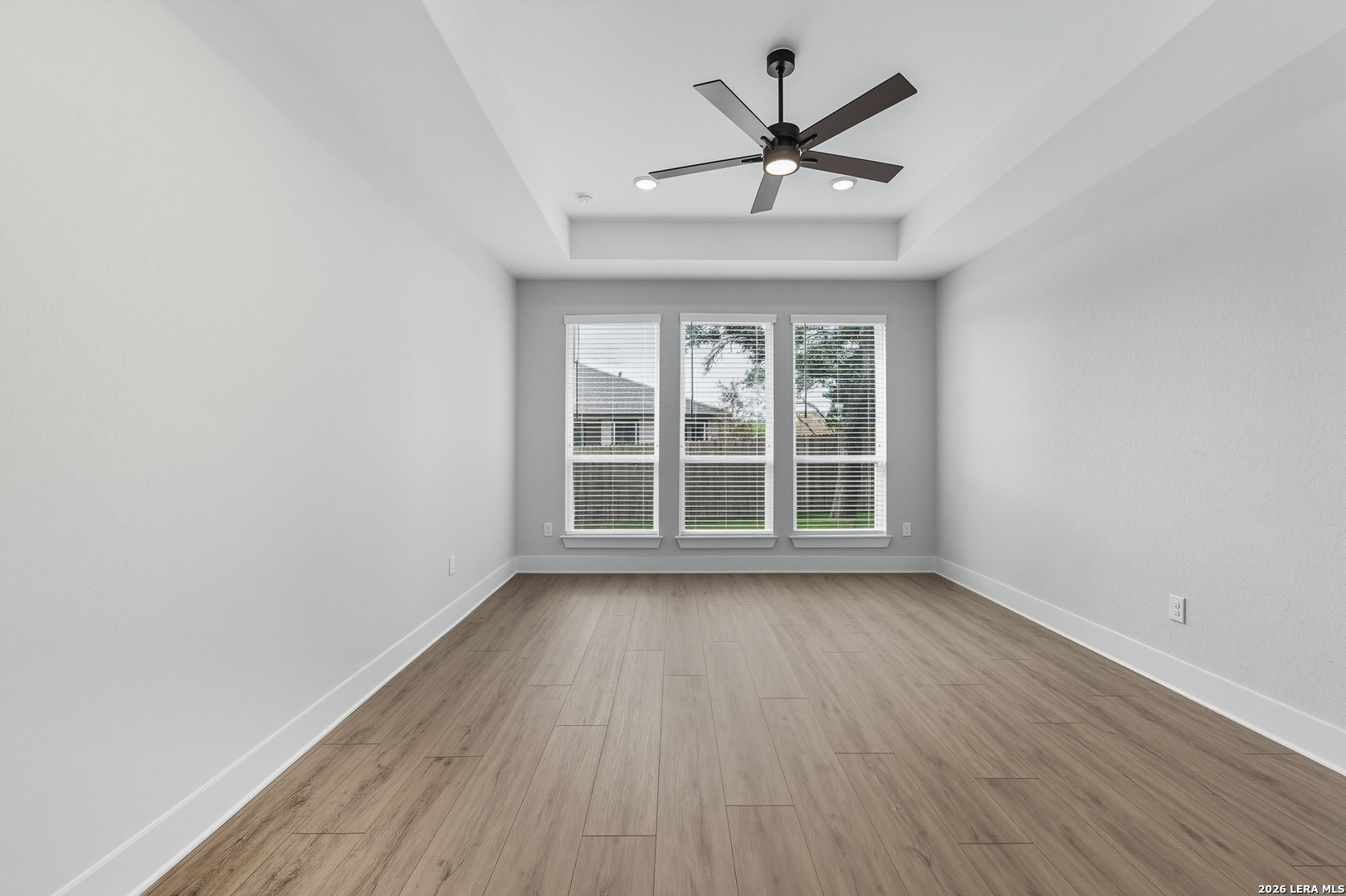 210 Kari Drive Castroville, TX 78009 - Photo 16 of 29 an empty room with wooden floor ceiling fan and windows